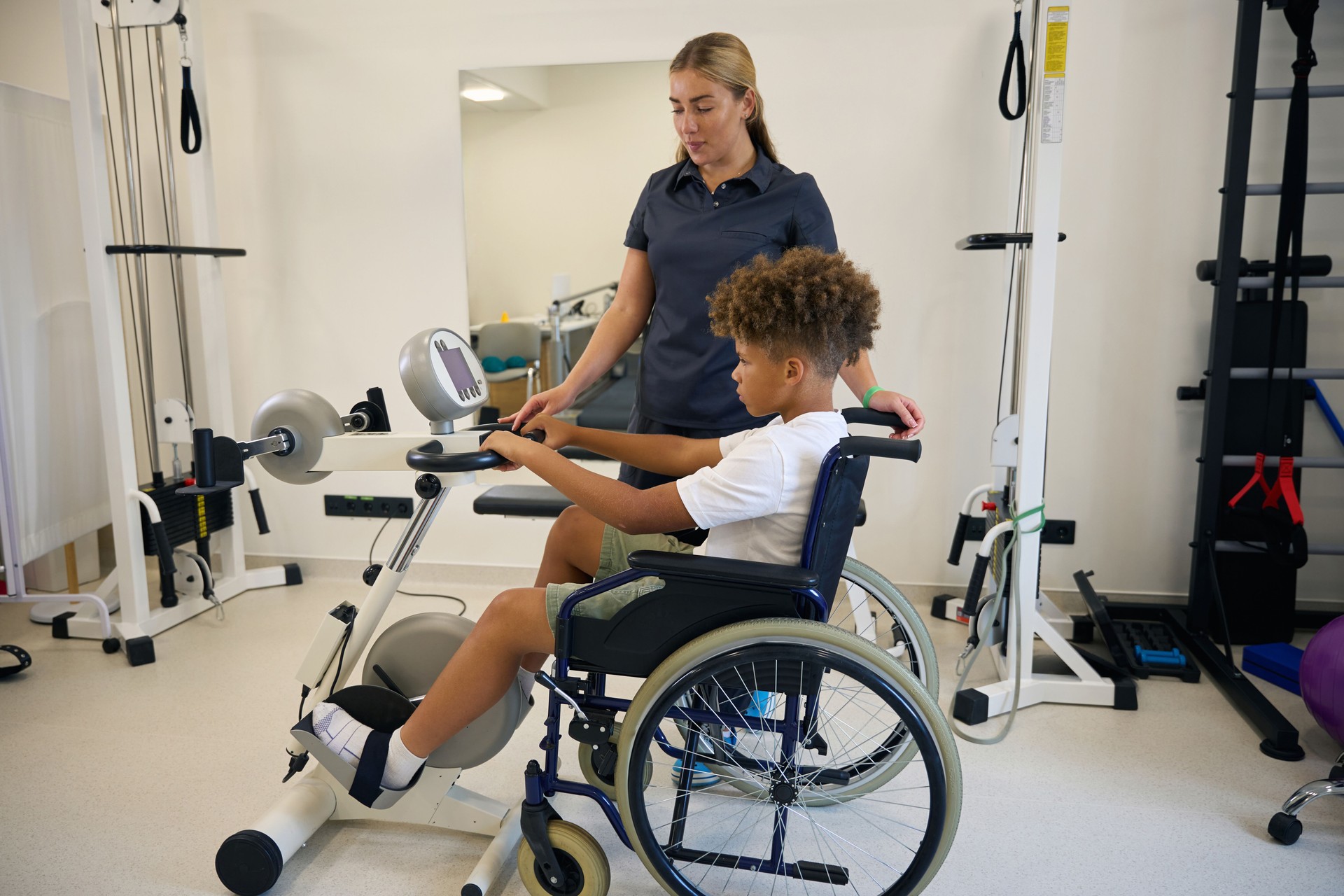 Young patient performs upper body exercises in a wheelchair