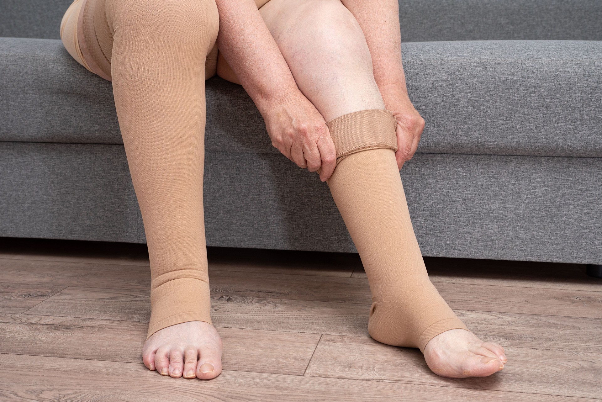 woman puts on medical compression underwear on her legs. Stockings to maintain the tone of veins and valves.